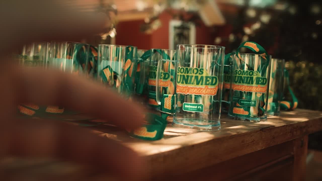 Copos personalizados do Festival Somos Unimed 2025 sobre o balcão do bar
